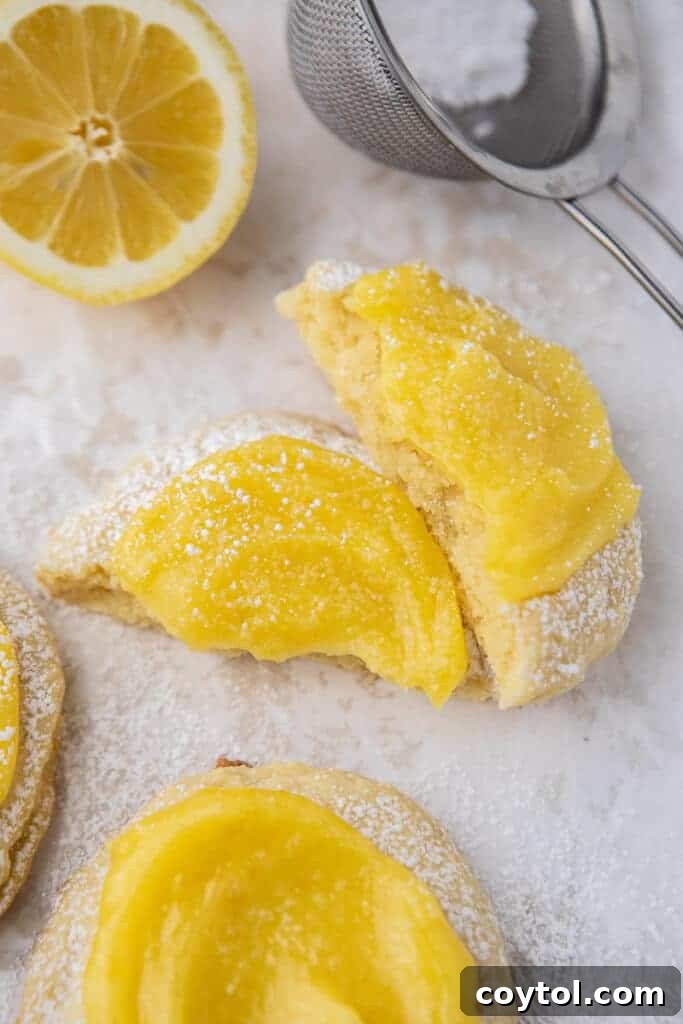 Zesty Chilled Lemon Bar Cookies 12 Lemon curd cookie broken in half, showing the cross-section