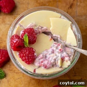 Raspberry overnight oats in a jar with a spoon