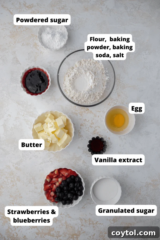 Fresh ingredients for Berries and Cream Cookies laid out, including butter, eggs, flour, sugars, blueberries, and strawberries.