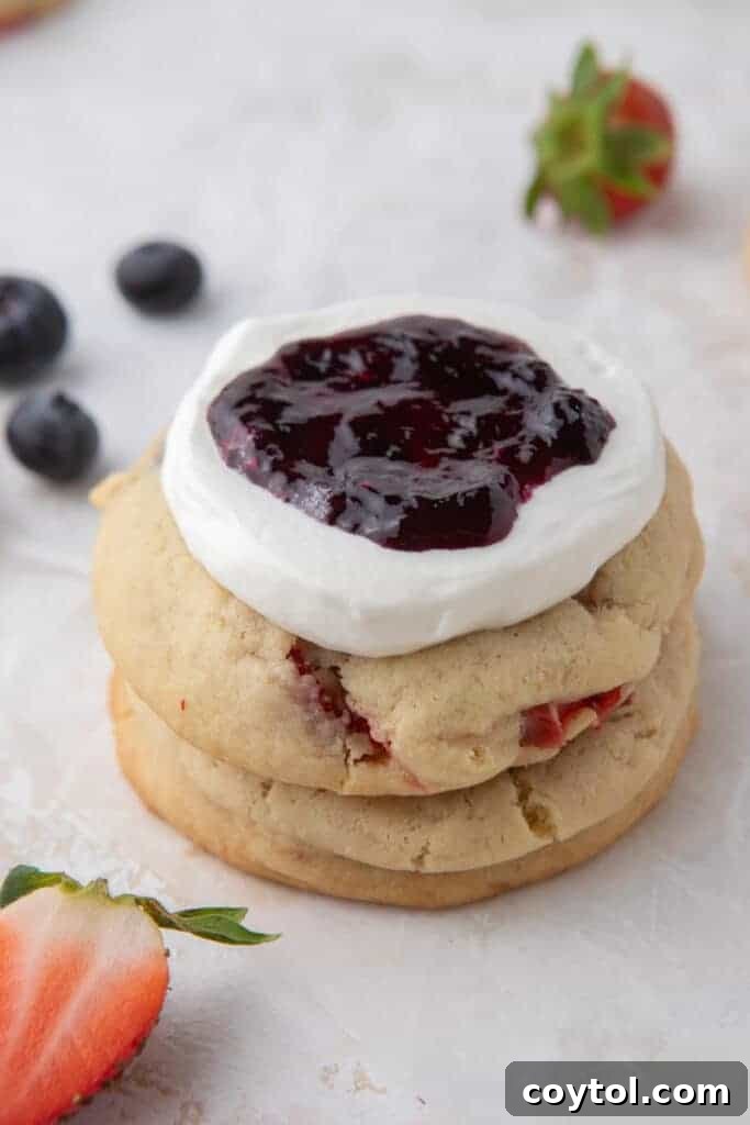 A close-up of a Crumbl Berries and Cream Cookie, highlighting the fluffy whipped cream and vibrant berry topping.