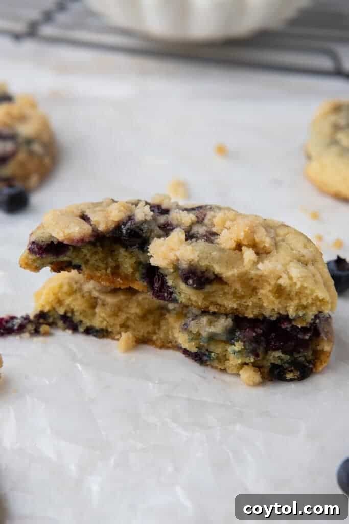 Blueberry Muffin Cookie Bliss: Crumbl-Style with Streusel 11 Crumbl blueberry muffin cookie cut in half, showing interior