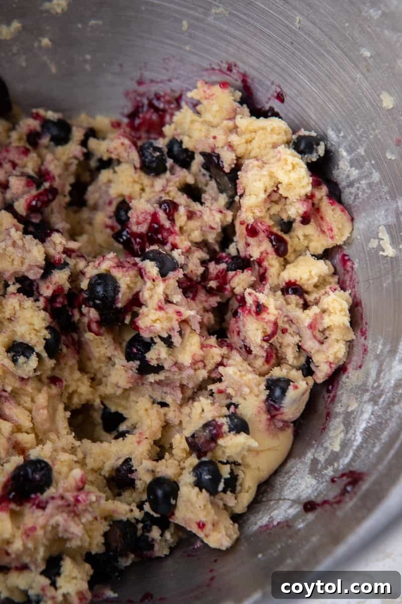 Blueberry Muffin Cookie Bliss: Crumbl-Style with Streusel 7 Blueberry cookie dough with jam swirls in mixing bowl