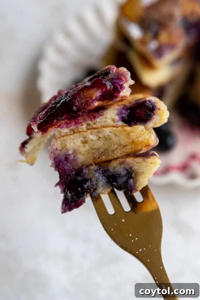 Fork full of fluffy ricotta lemon pancakes with blueberries