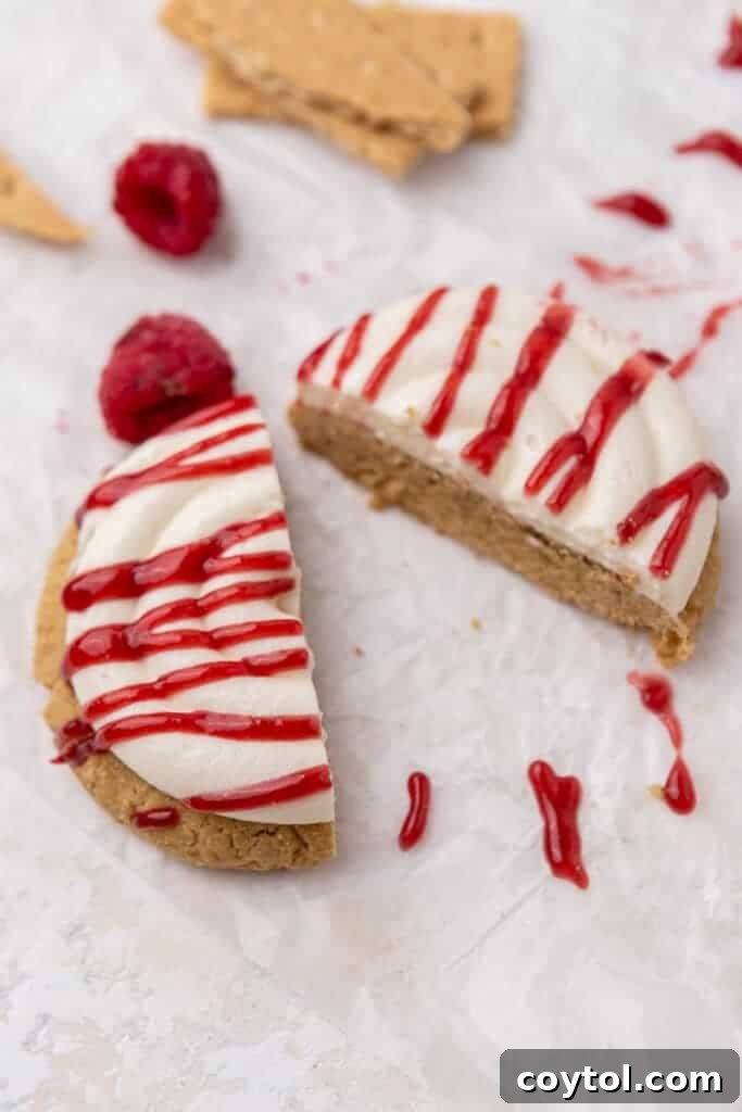 Irresistible Crumbl Raspberry Cheesecake Cookies 11 A raspberry cheesecake cookie cut in half to show its soft interior