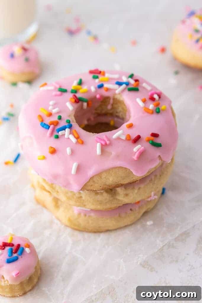 A stack of delicious Crumbl pink doughnut cookies with glaze and sprinkles