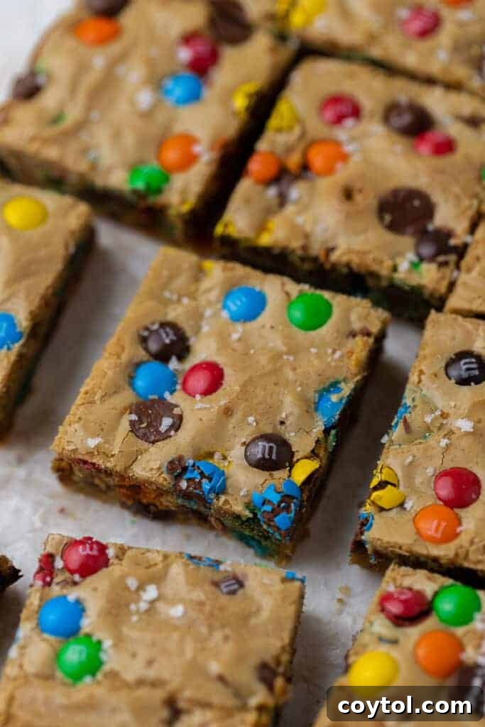 Chewy M&M Chocolate Chip Blondie Bars 3 A perfectly square slice of M&M chocolate chip blondie, showcasing its chewy texture and colorful candies