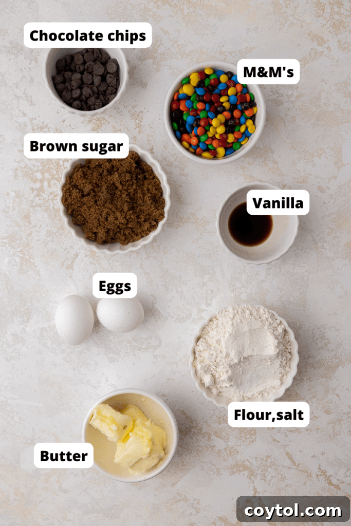 Chewy M&M Chocolate Chip Blondie Bars 4 A selection of raw ingredients for M&M's blondies, including butter, sugar, eggs, flour, chocolate chips, and M&M's