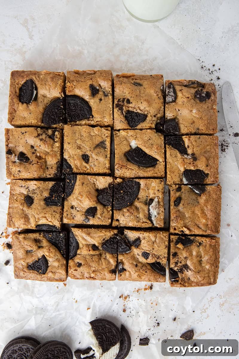 Freshly baked brown butter Oreo blondies cooling in the pan, showcasing their perfectly crinkly, golden-brown top and fudgy texture.