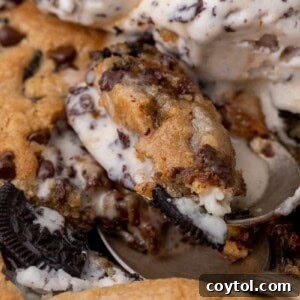 Simple Skillet Oreo Cookies and Cream Pizookie 11 Close-up of a cookies and cream skillet cookie with a scoop of melting vanilla ice cream.