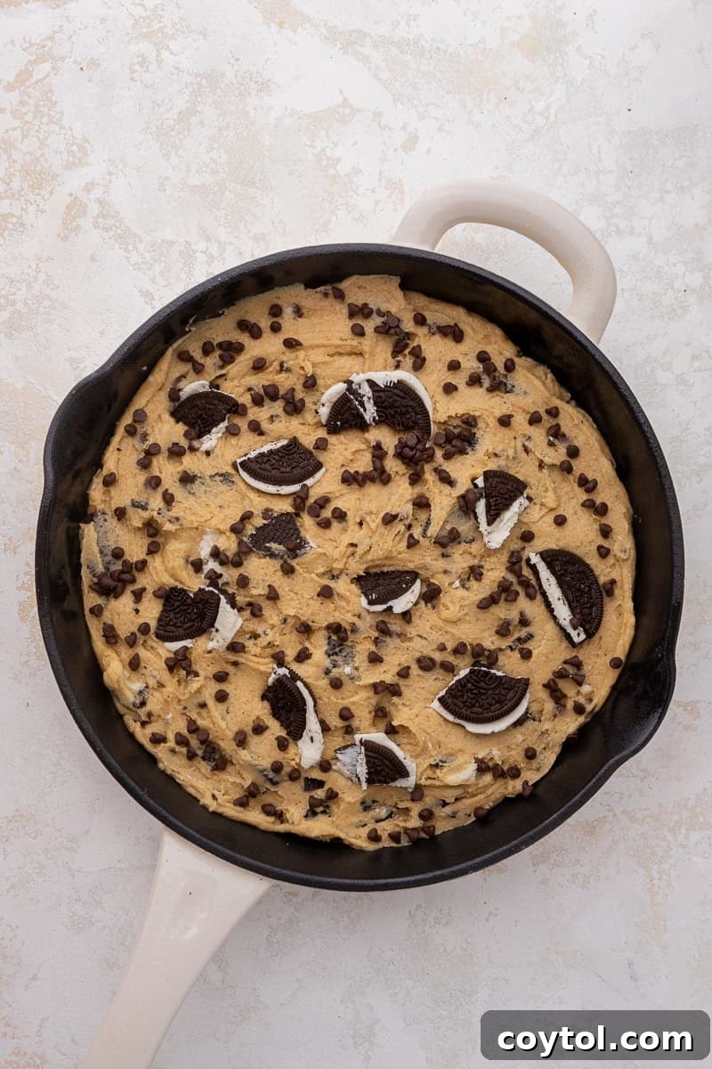 Simple Skillet Oreo Cookies and Cream Pizookie 6 Cookie dough spread evenly in a cast iron skillet.