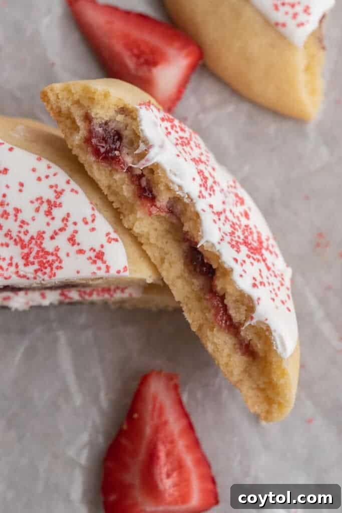 Overhead shot of a strawberry pop tart cookie broken in half, revealing the jam filling