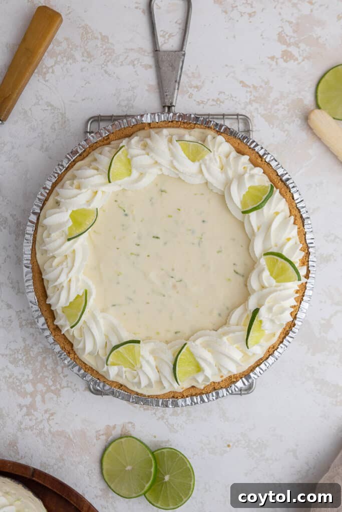 Overhead shot of a full no-bake key lime pie topped with whipped cream and lime slices
