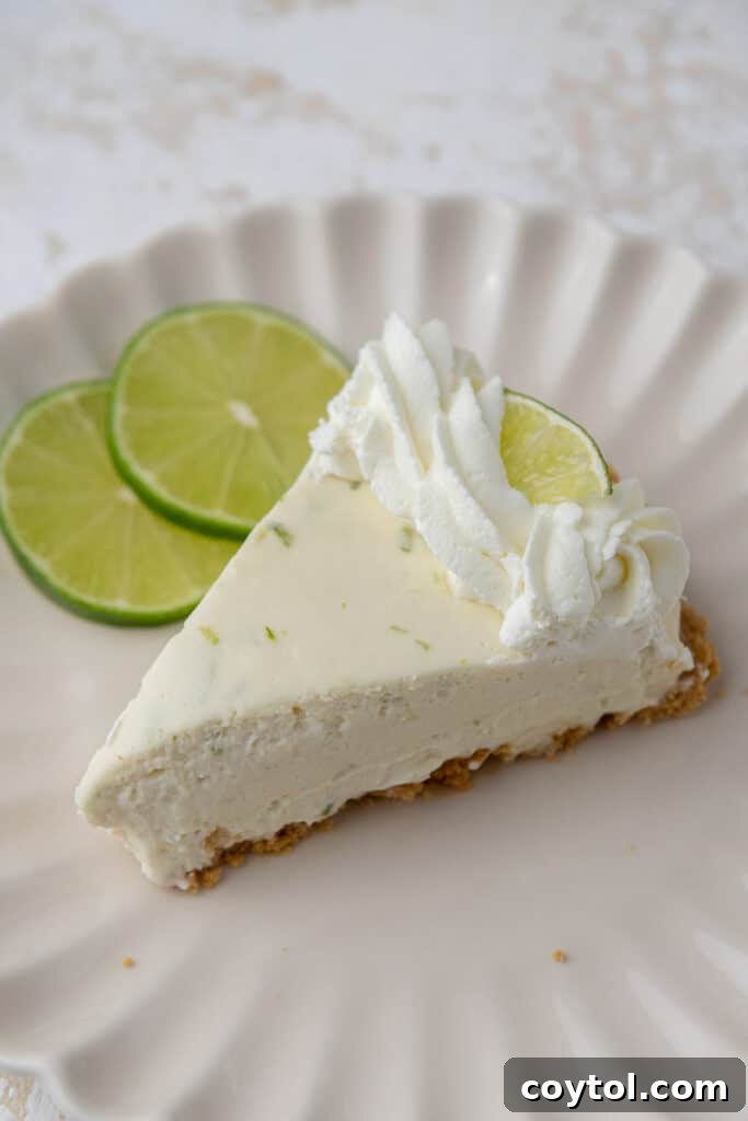 A single slice of no-bake key lime pie on a white plate with a fork.