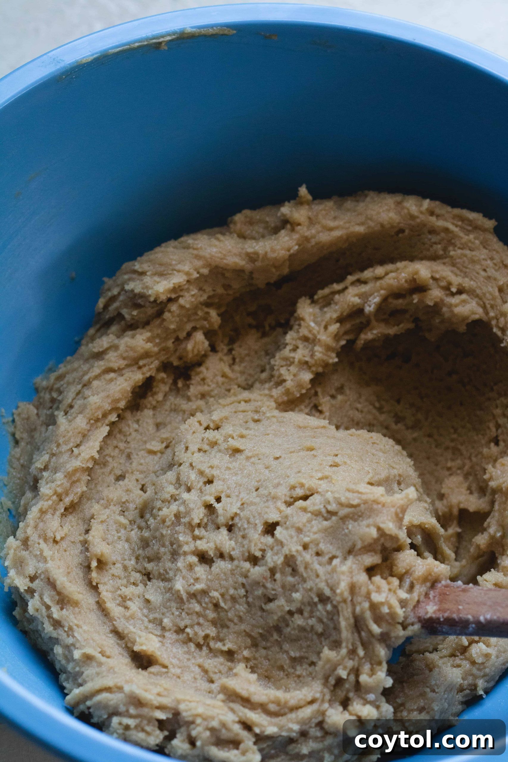 The rich, thick brown butter blondie mix in a bowl, ready to be transferred to the baking pan.