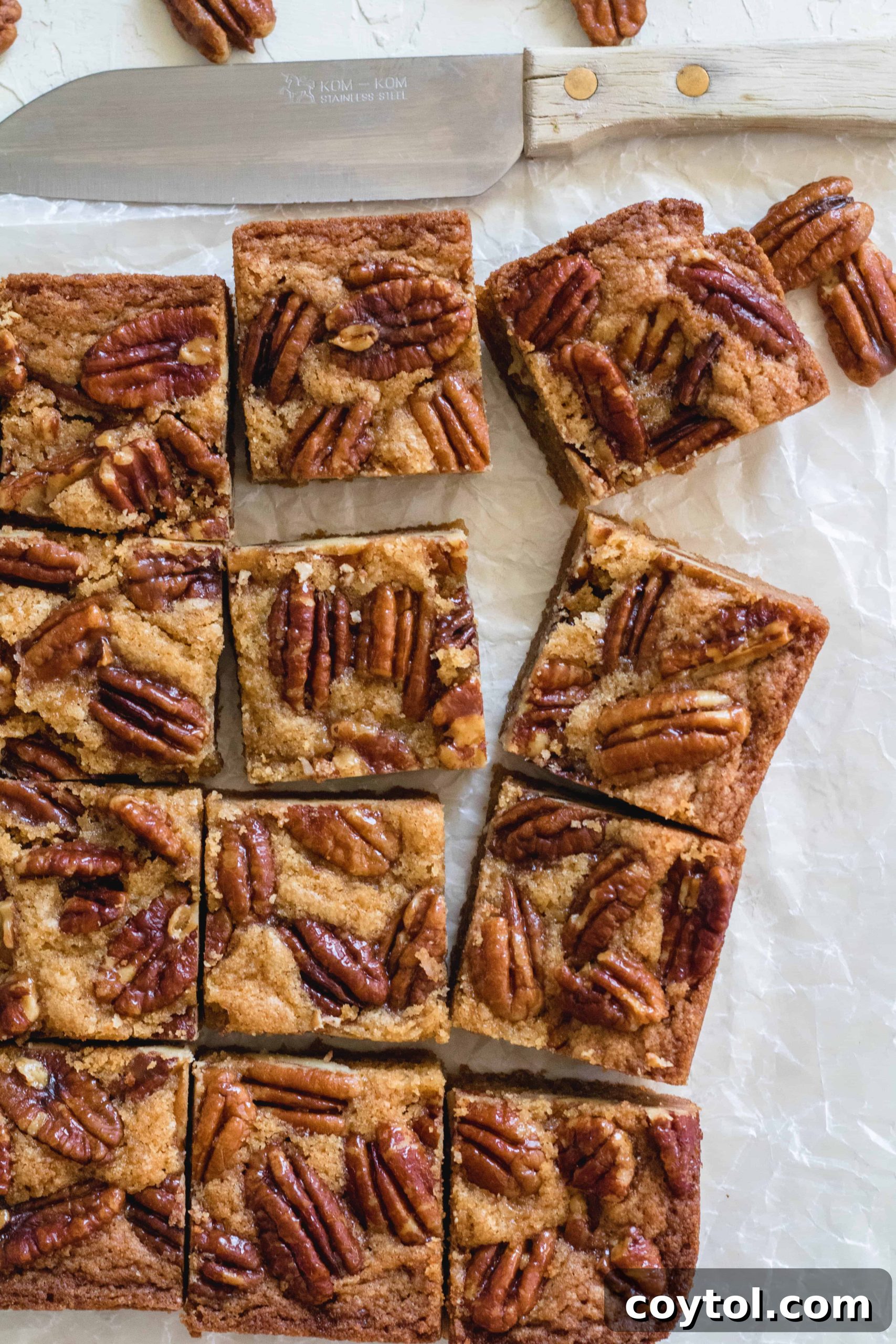 Perfectly sliced brown butter candied pecan blondies on a cutting board, ready to be served.