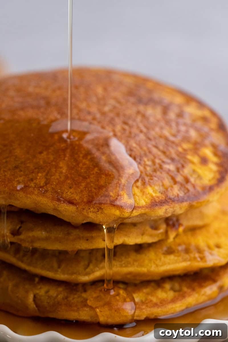 A stack of perfectly cooked fluffy pumpkin pancakes with pancake mix, glistening with syrup.