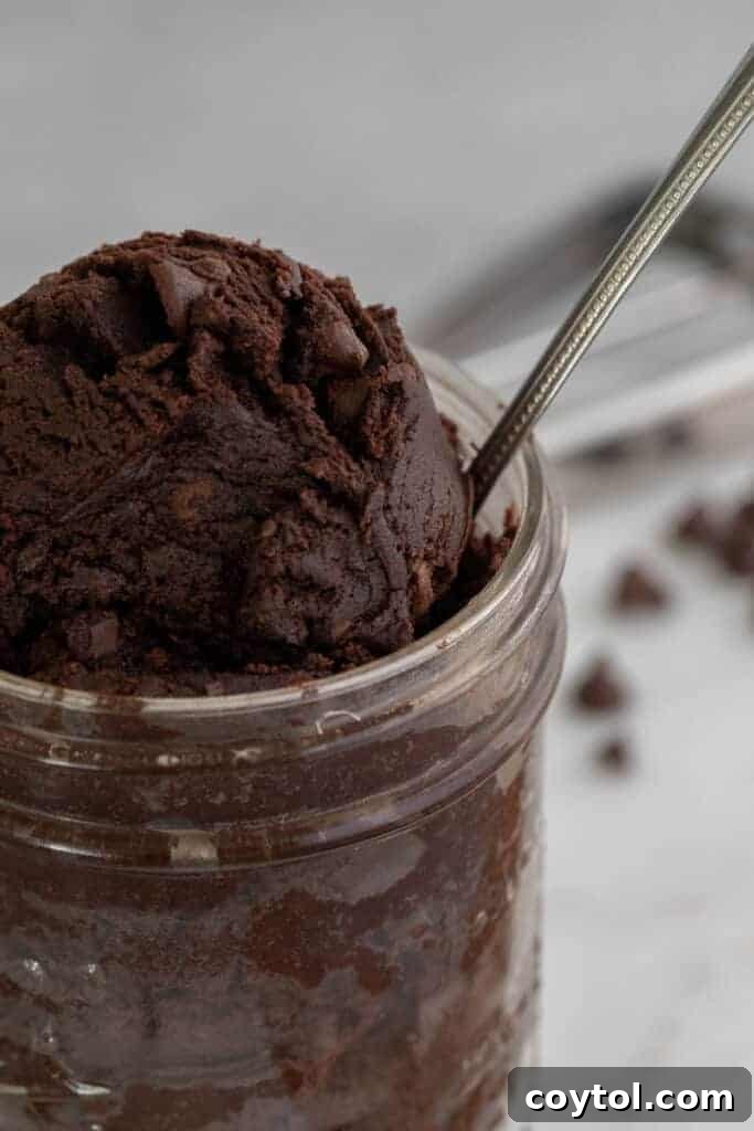 Close-up of chocolatey brownie cookie dough in a bowl with a spoon