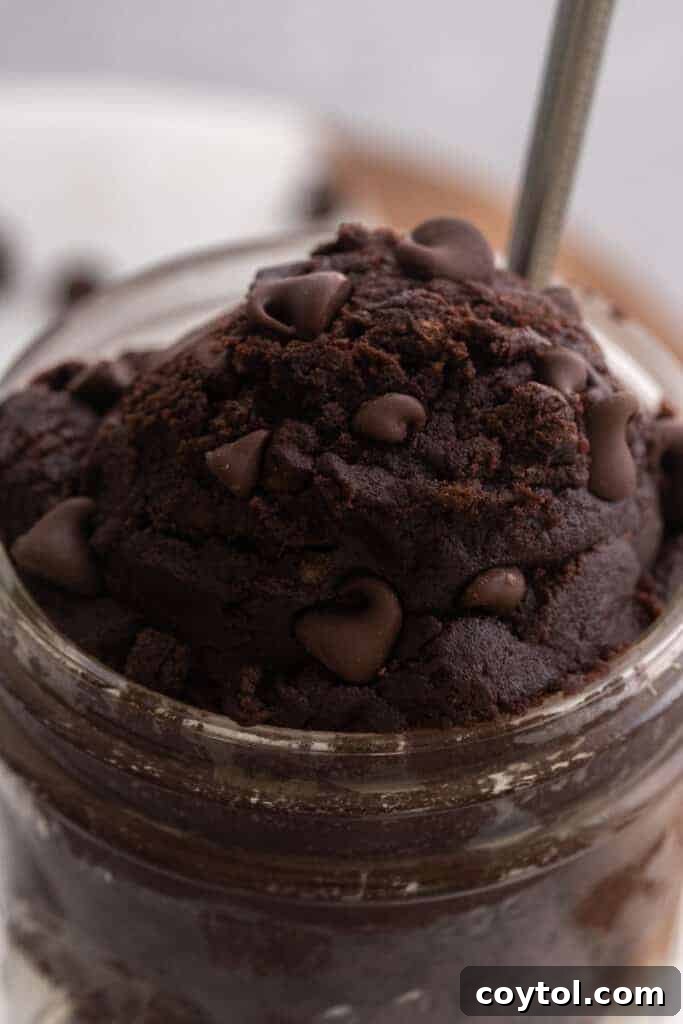 Scoop of brownie batter in a small white cup, ready to eat