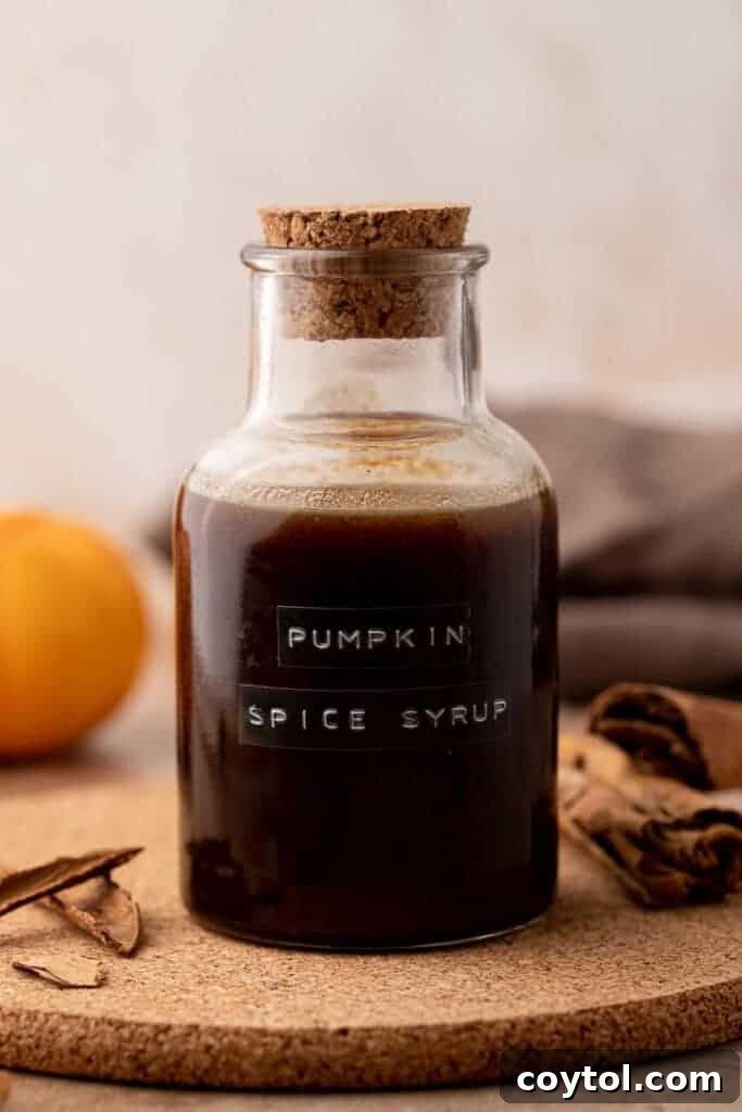 Homemade pumpkin spice latte syrup in a glass bottle with fall decor