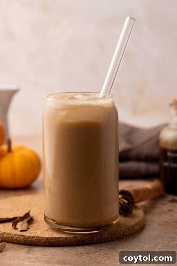 Iced pumpkin spice latte with whipped cream and a cinnamon stick