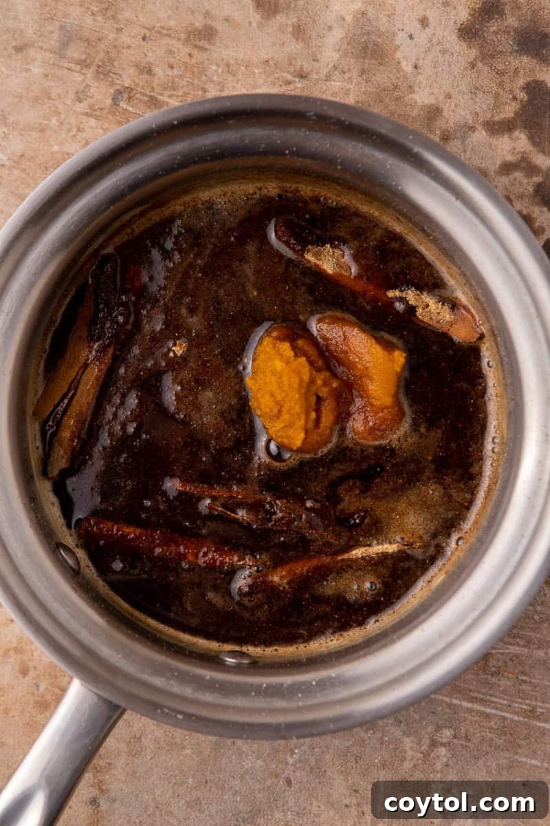 Pumpkin puree and spices added to the sugar syrup in a pot