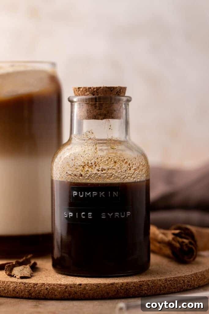 Pumpkin spice syrup in a glass bottle on a rustic wooden surface