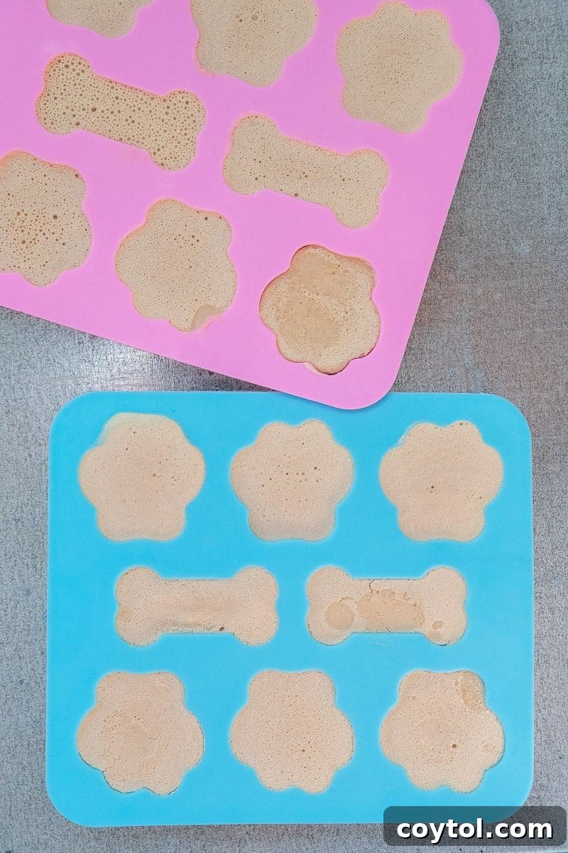 Peanut Butter Banana Pupsicles for Dogs 7 Smoothie mixture being poured into paw print silicone molds