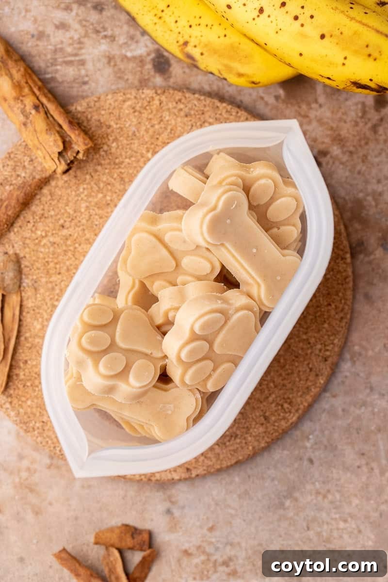 Peanut Butter Banana Pupsicles for Dogs 8 Frozen peanut butter banana dog treats in paw and bone shapes, ready to be served