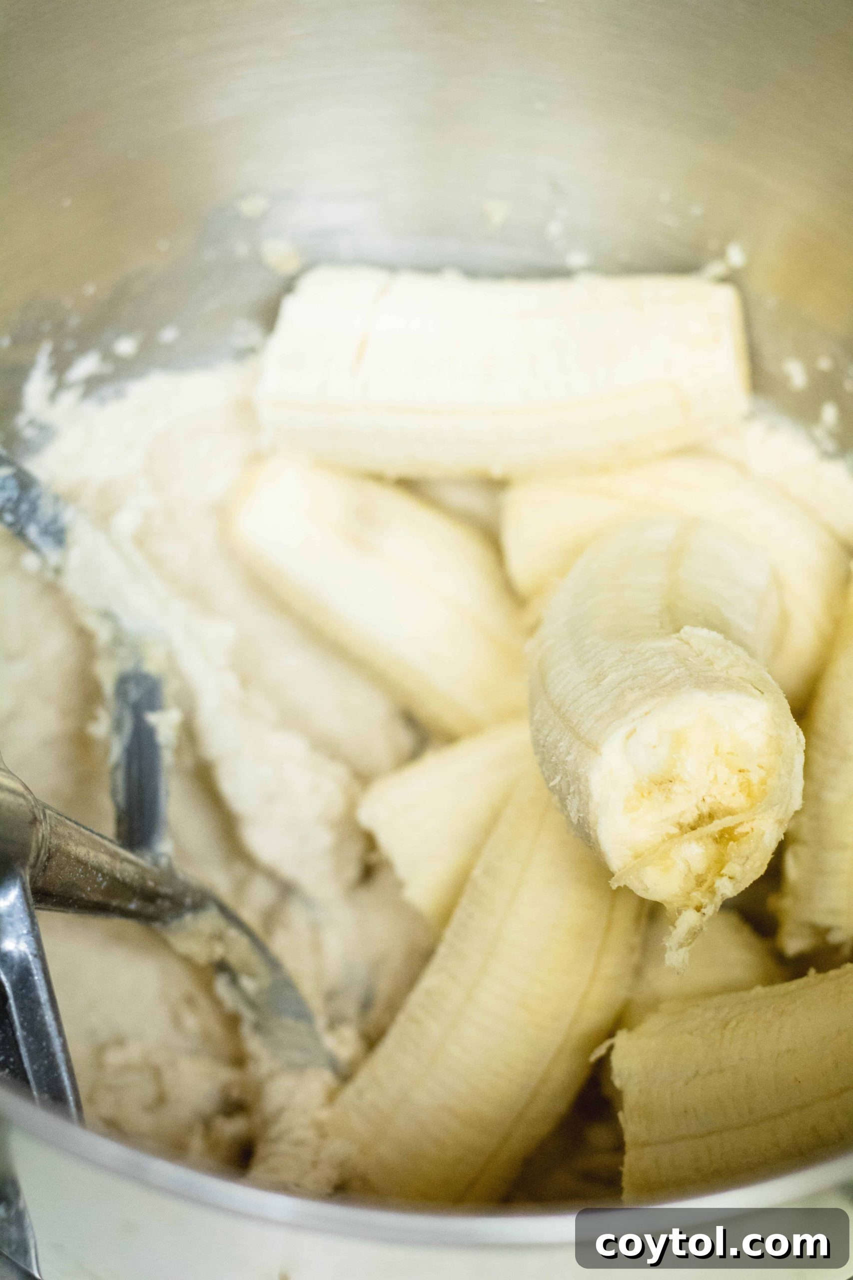 Adding ripe bananas to the muffin mix.