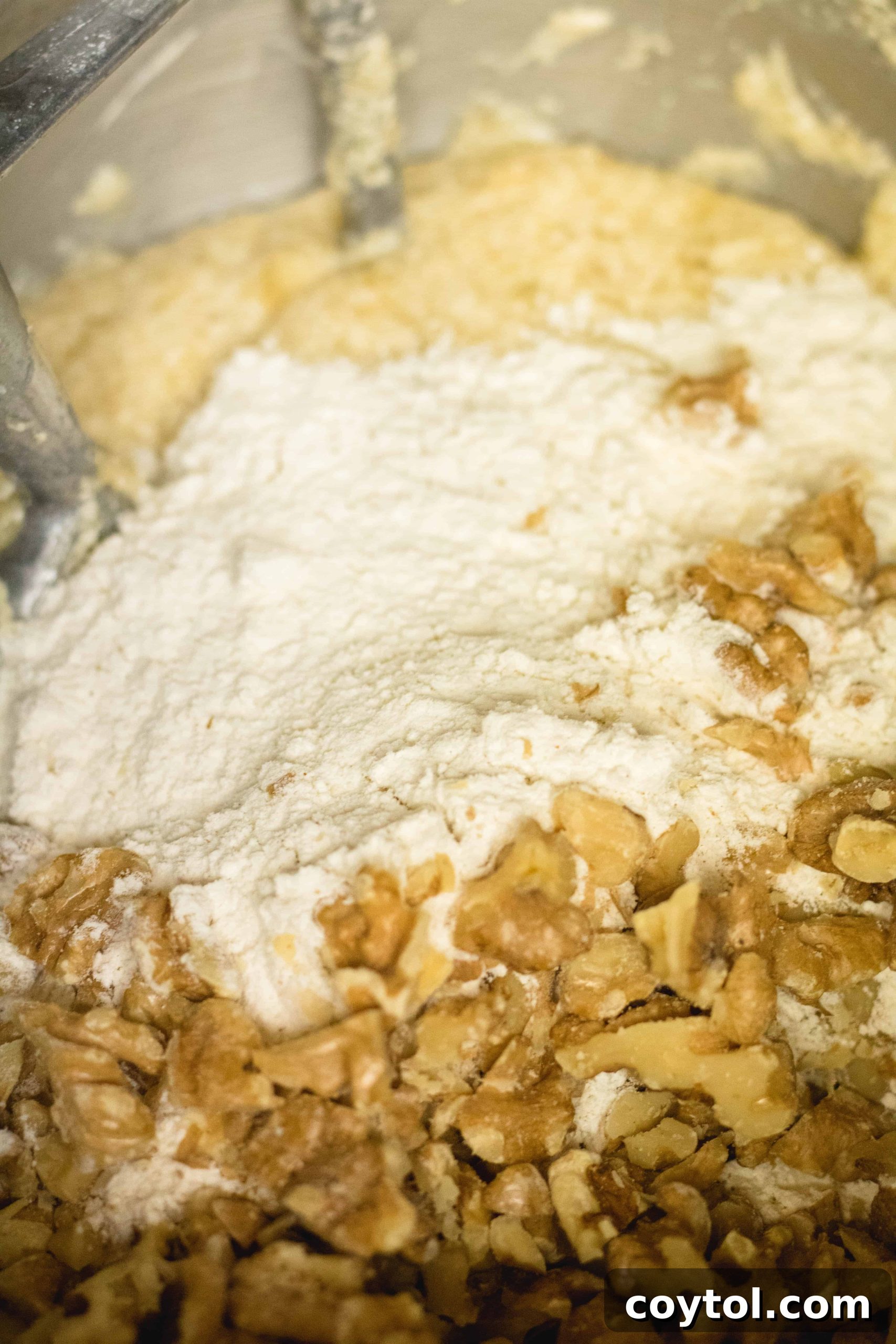 Adding dry ingredients to the wet ingredients for banana muffins.