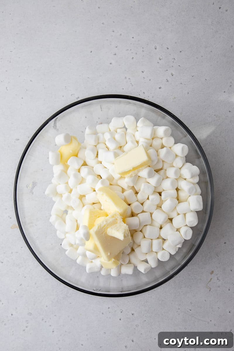 Crumbl-Style No-Bake Rice Krispies Treats 4 Marshmallows and butter in a bowl