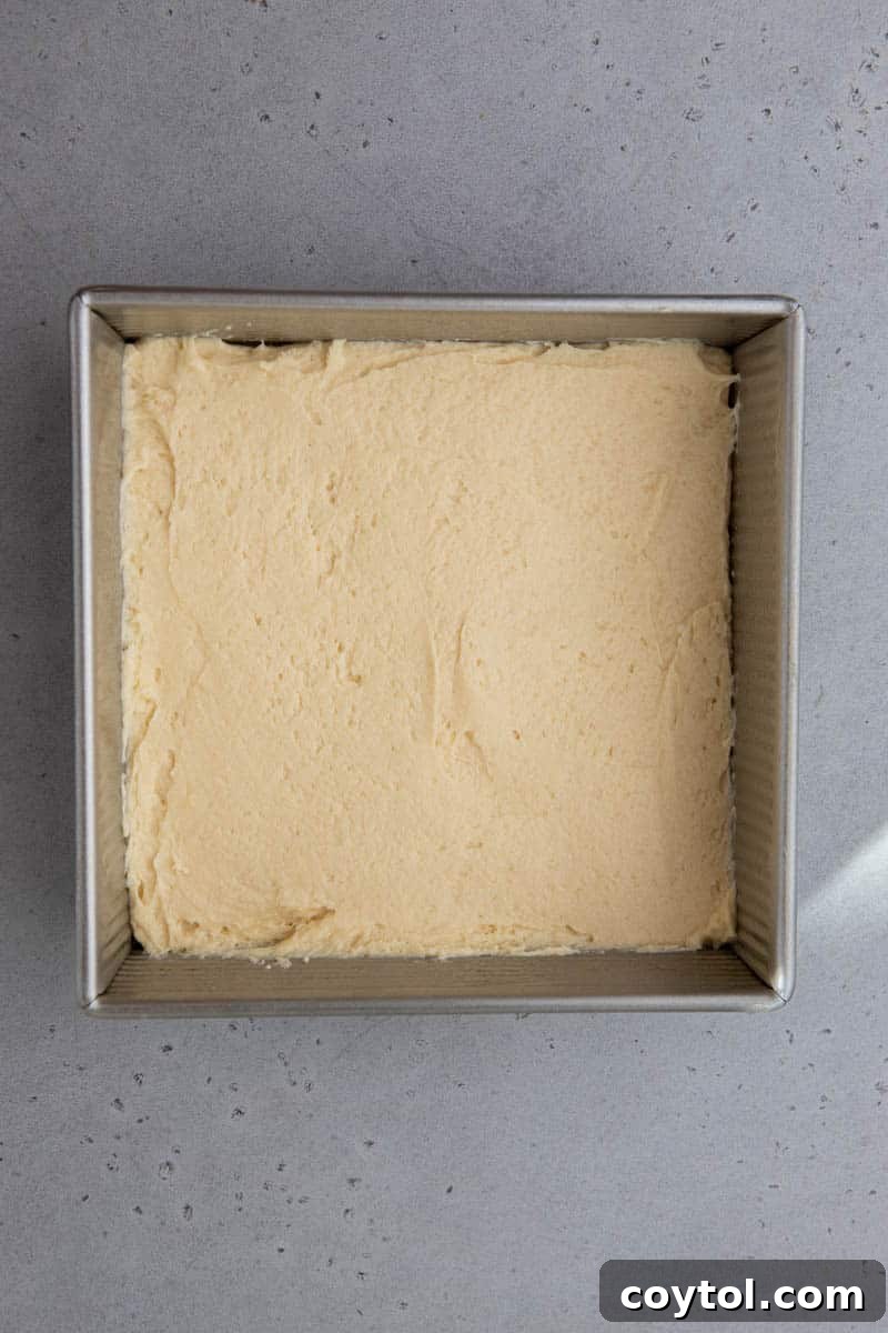 Half of the cake batter spread in a baking sheet