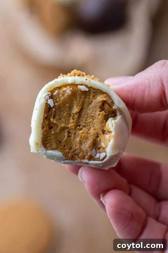 Pumpkin truffle with a bite taken out of it, showing creamy orange interior