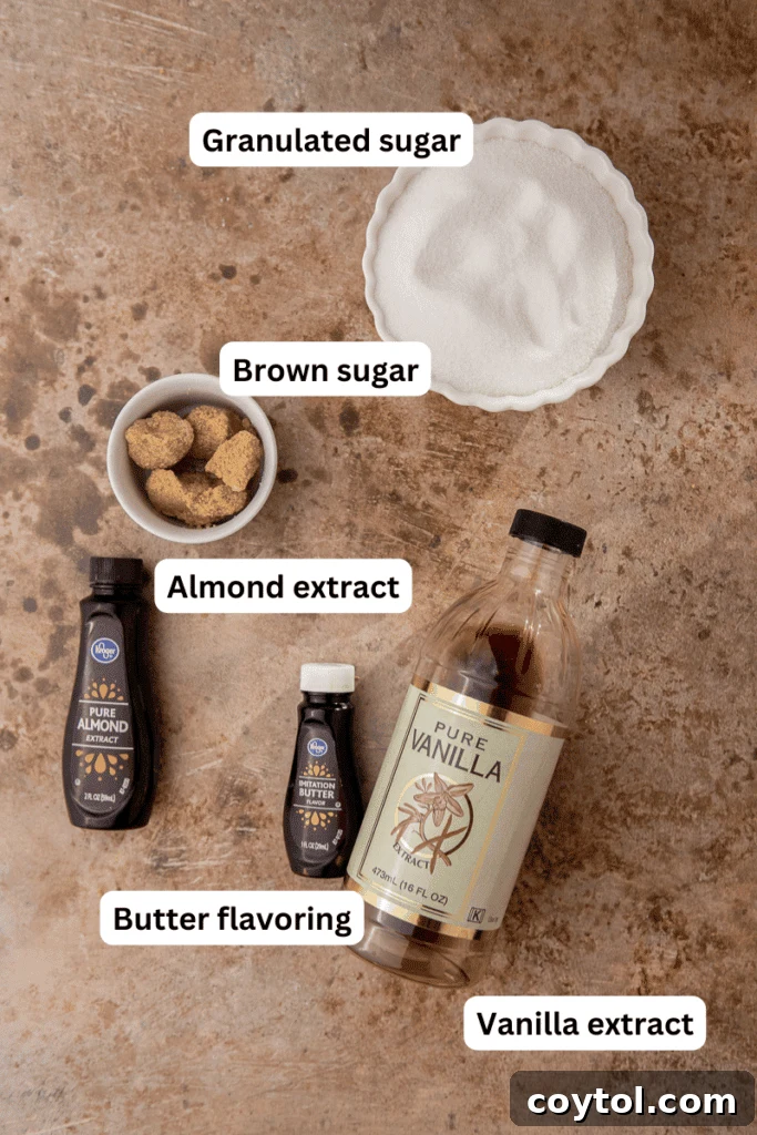 Carefully laid out ingredients on a rustic countertop for making sugar cookie syrup, including sugars, extracts, and measuring tools, highlighting simplicity.