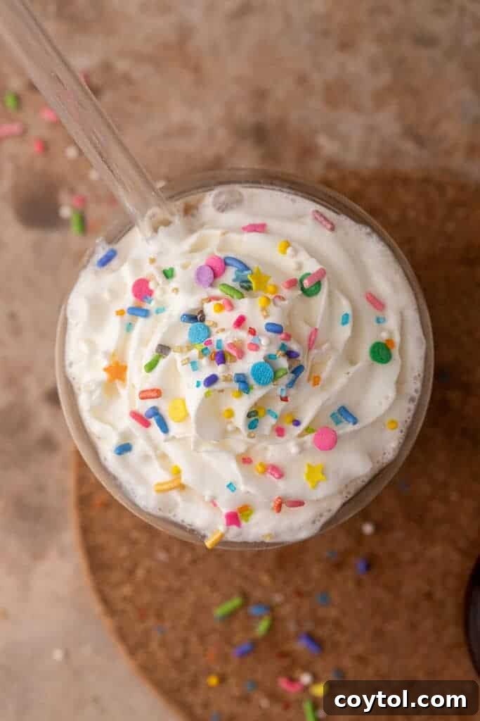 A festive iced sugar cookie latte topped with colorful sprinkles, showcasing the perfect application of the homemade syrup for a delightful holiday drink.
