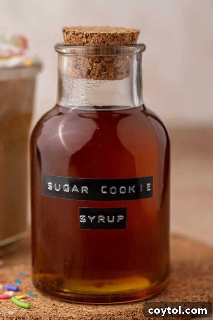 A close-up shot of the homemade Starbucks Sugar Cookie Syrup, showing its golden hue and inviting texture in a glass container.