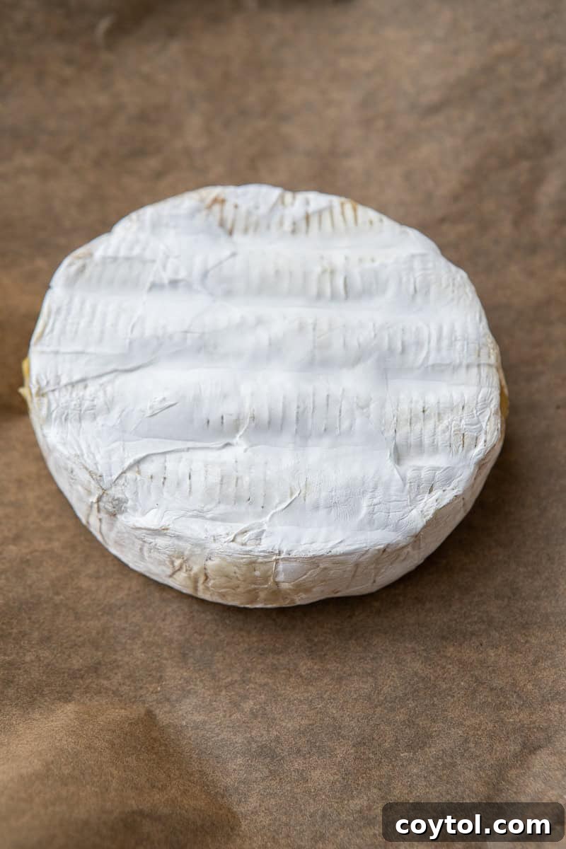 Unwrapped brie cheese ready for baking