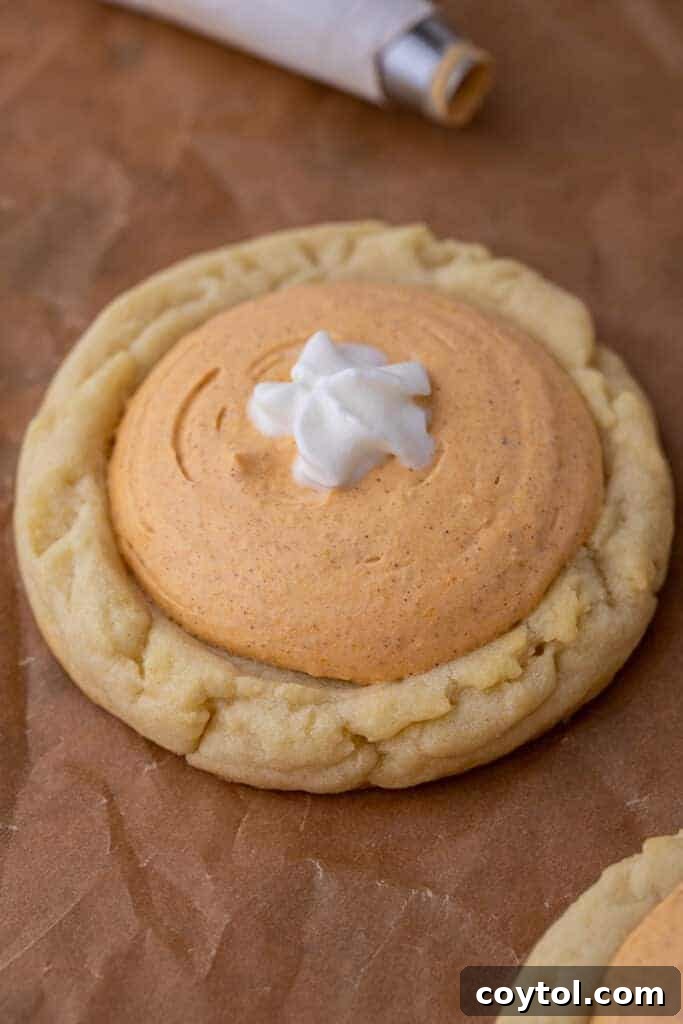 Crumbl's Divine Pumpkin Pie Cookies 11 Close up of a cluster of Crumbl pumpkin pie cookies, beautifully decorated with creamy pumpkin filling and whipped cream swirls.