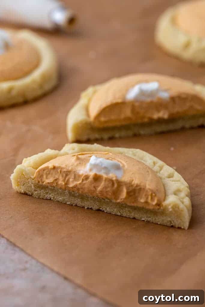 Crumbl's Divine Pumpkin Pie Cookies 4 A delicious Crumbl pumpkin cookie sliced in half, revealing its thick, soft texture and the generous layer of creamy pumpkin pie filling.