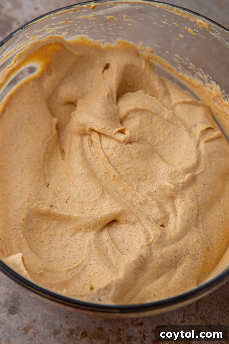 Crumbl's Divine Pumpkin Pie Cookies 9 Rich, orange pumpkin pie mousse filling in a bowl, ready to be piped.