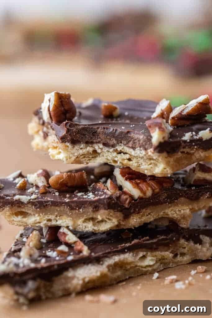 Close-up of freshly made Christmas Crack topped with chopped pecans, highlighting the texture and glistening chocolate.