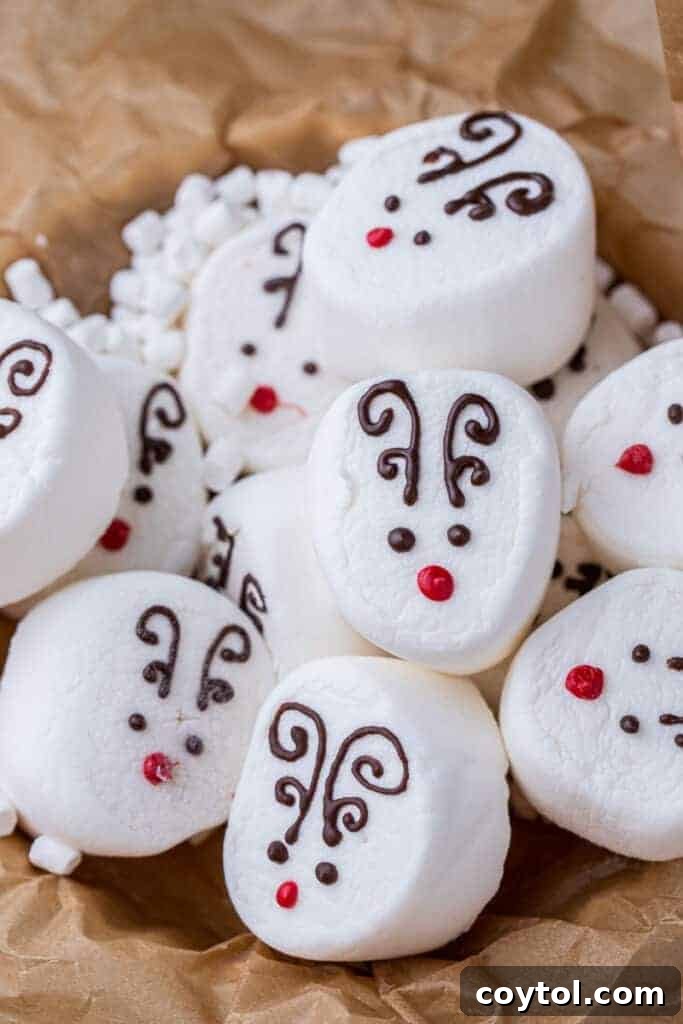 Reindeer marshmallow hot cocoa toppers floating in a festive mug