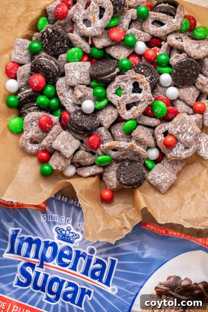 Christmas snack mix coated in powdered sugar on parchment paper