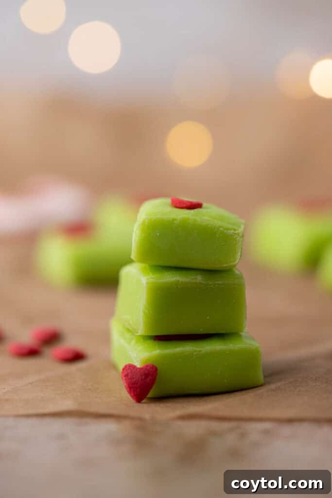 Stack of thick green Grinch fudge with red heart sprinkles