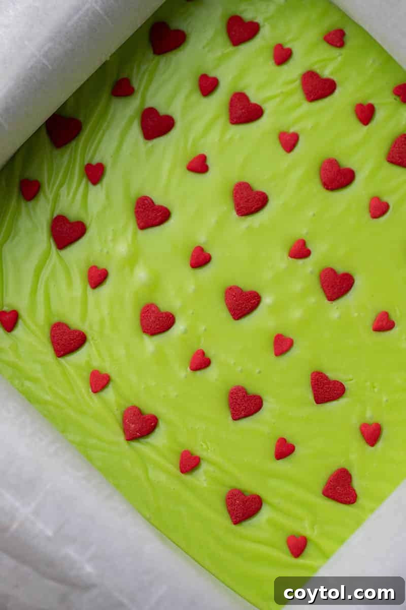 Grinch fudge setting in a pan, topped with sprinkles