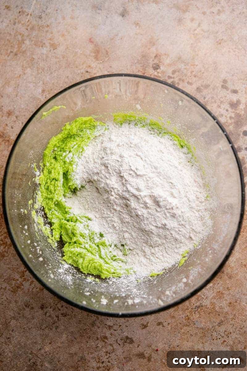 Vibrant green cookie dough in a mixing bowl, showcasing the result of adding food coloring.