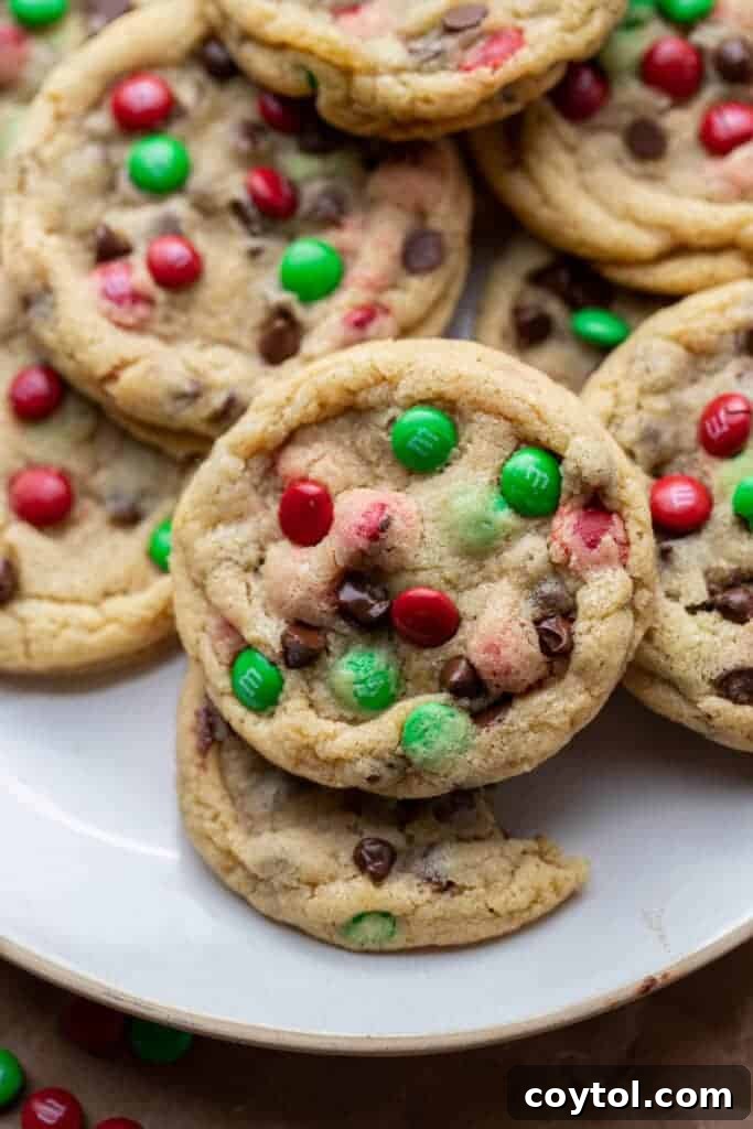 Sparkling Christmas M&Ms Chocolate Chip Cookies 10 A close-up of a single Christmas M&M chocolate chip cookie, showcasing its chewy texture and colorful candies