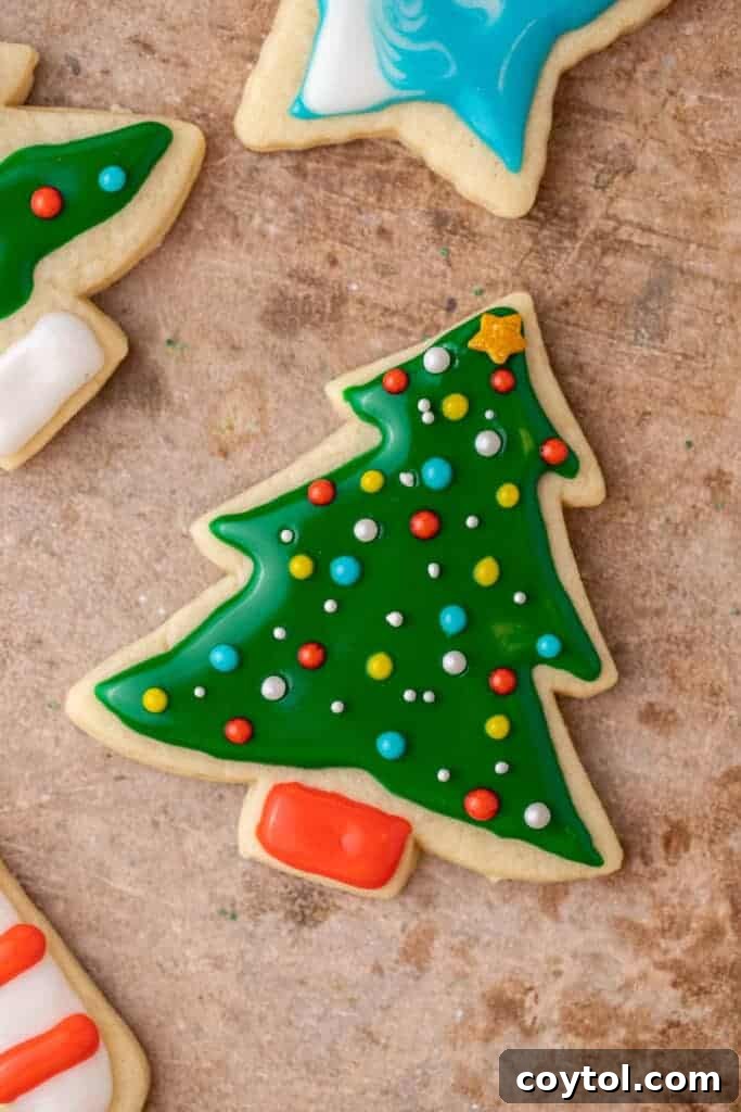 Decorated Christmas tree sugar cookie made with glossy green icing and colorful sprinkles.