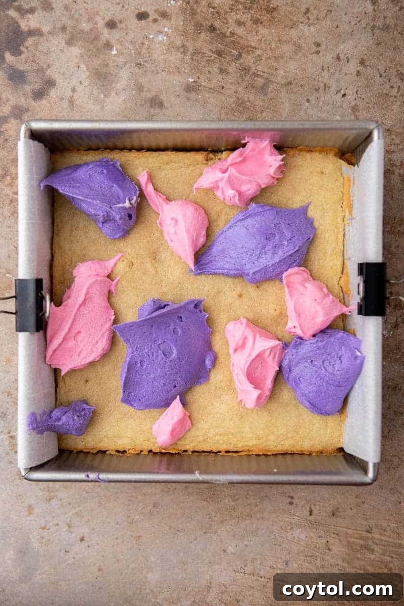 Dollops of pink and purple frosting on cookie dough
