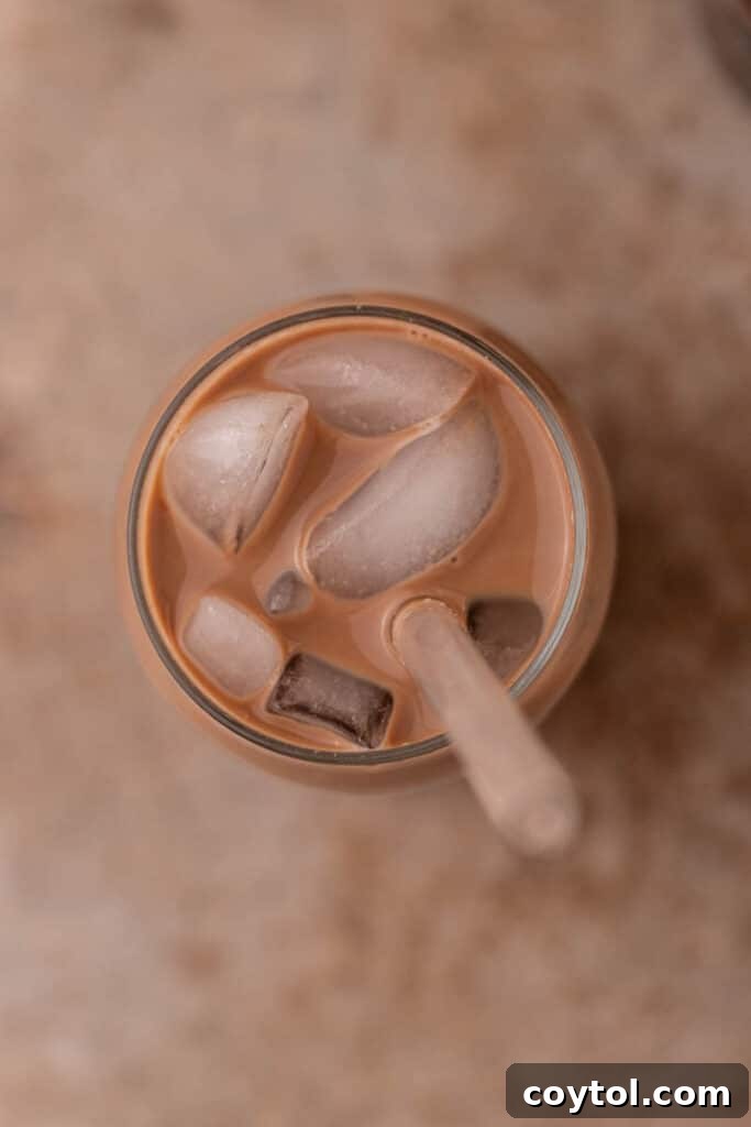 Overhead shot of a beautifully layered homemade mocha creme cold brew with sweet cream on top and chocolate drizzle.